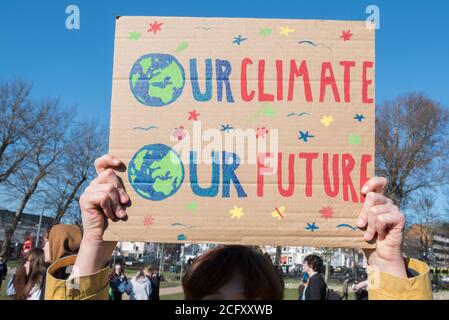 Signs at the school climate strike where youths protested about the growing Climate crisis that our planet is facing holding home made signs Stock Photo