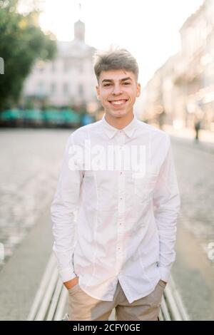 Young stylish Caucasian man wearing white shirt and beige pants