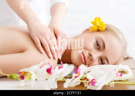 Relaxing in spa. Smiling girl lies on massage table Stock Photo