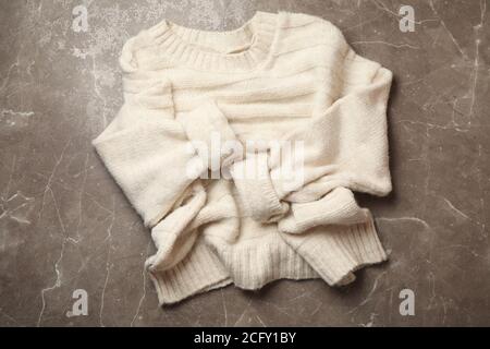 Knitted sweater on gray background, top view Stock Photo