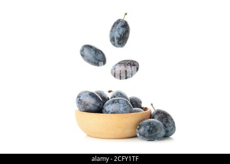 Falling plums and bowl with plums isolated on white background Stock Photo