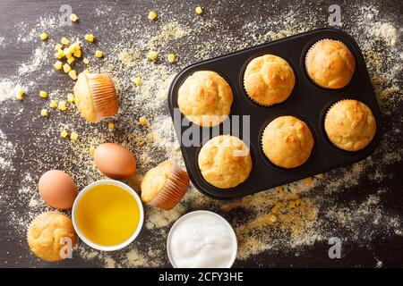 Healthy corn muffins in a baking dish and ingredients close-up on the table. horizontal top view from above Stock Photo