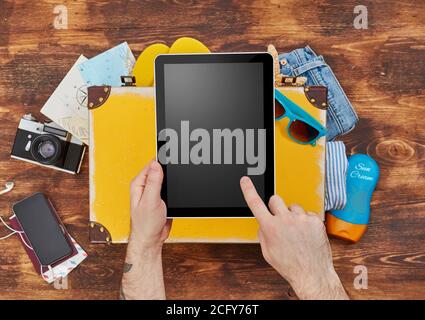 Digital tablet, suitcase, clothing and personal accessories Stock Photo