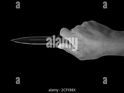 Closeup Hand Holding a Combat Knife Isolated on Black Background, Black and White with Clipping Path Stock Photo