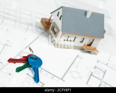 Keys and model house on blueprints Stock Photo