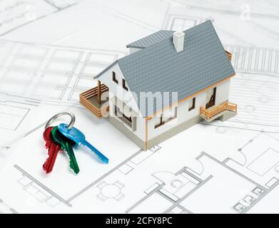 Keys and model house on blueprints Stock Photo