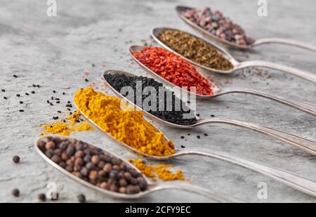 Spoons with spices on gray stone close-up Stock Photo