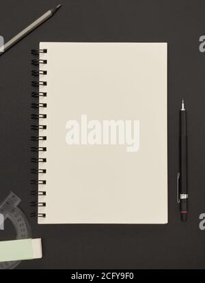 Notebook, pencil and eraser on blackboard Stock Photo