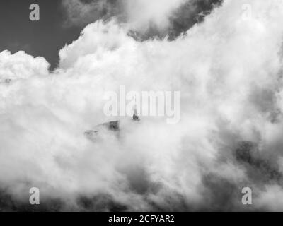 Television relay tower station on Costila Peak in Bucegi mountains Romania. Black and white landscape with clouds over the Carpathian Mountains. Stock Photo