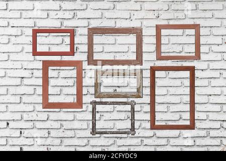 old photo wood frames on white brick wall. Wooden picture frame. Stock Photo