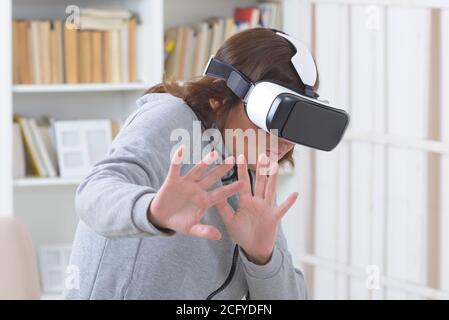 Woman using virtual reality headset at home Stock Photo