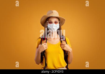 Girl tourist with backpack wearing protective mask Stock Photo