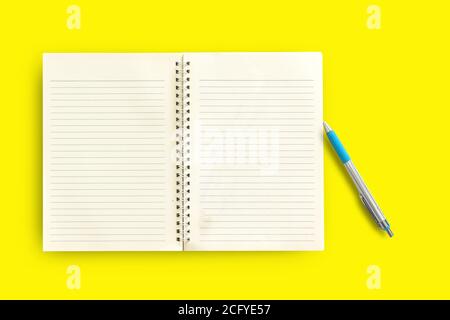 Notebook,pen on a yellow background. top view copy space Stock Photo
