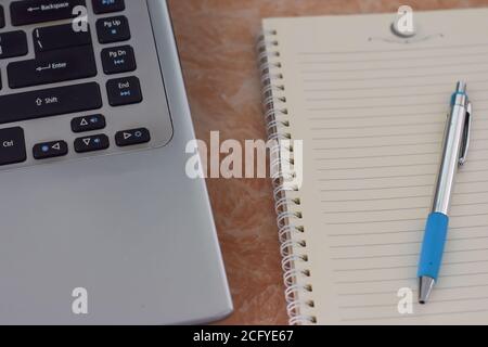 Computer laptop, notebook and pen on work office desk. (selective focus) Stock Photo