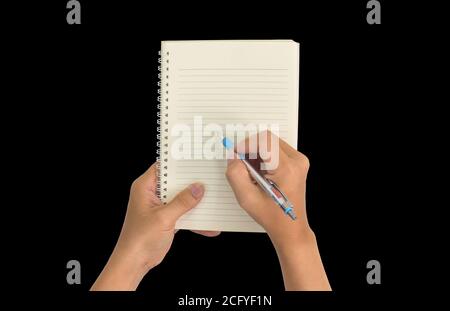 Hand holding pen, with a blank notes over blackboard background. Design concept Stock Photo