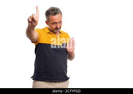 Angry adult man with serious expression making no stop stay away gesture using index finger and palm wearing casual summer tshirt isolated on white st Stock Photo