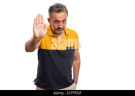 Angry adult male model with serious expression making stop stay away gesture using palm wearing black and yellow casual summer tshirt isolated on whit Stock Photo