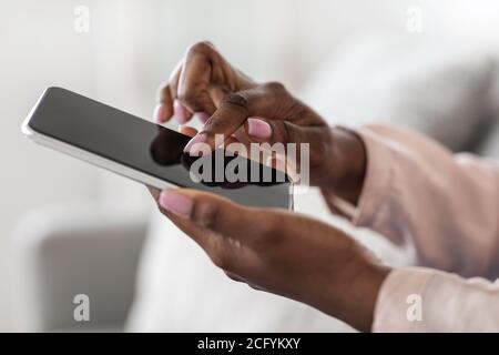 Unrecognizable African Woman Using Smartphone With Blank Black Screen, Mockup Image Stock Photo