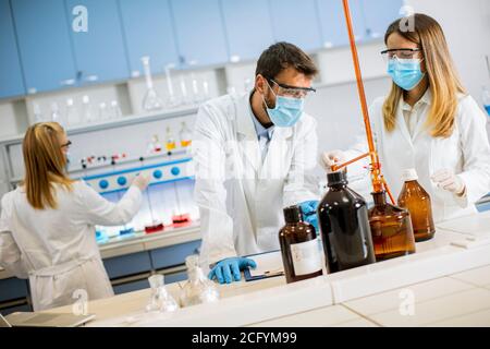 Young researchers analyzing chemical data in the laboratory Stock Photo