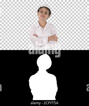 Professional woman in lab coat and white hardhat walking and smiling, Alpha Channel Stock Photo