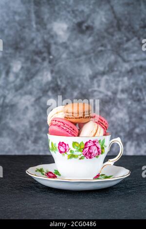 Colorful mini macarons in tea cup Stock Photo