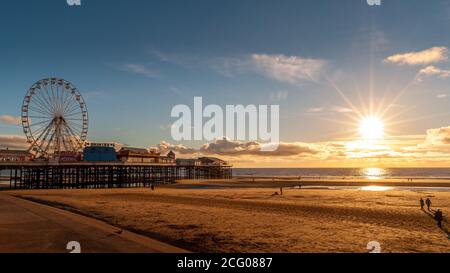 A view from Blackpool's golden mile beach with Central pier and the ferris wheel, taken at sunset Stock Photo