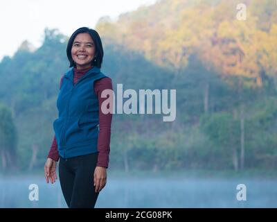 One asian lady standing near the lake in the forest. Stock Photo