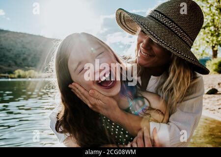 Mom holding young happy daughter while daughter laughs Stock Photo