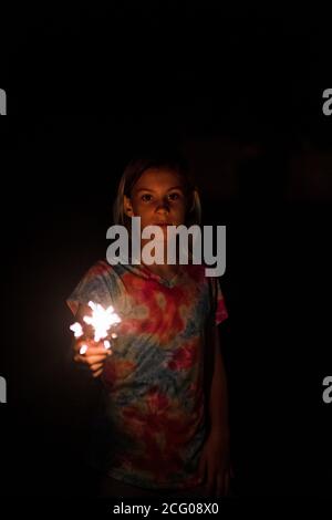 Girl holding sparkler on the 4th of july in kansas city missouri Stock Photo