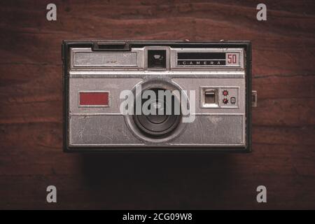 Old and worn photo camera from the 60s on rustic wooden table Stock Photo