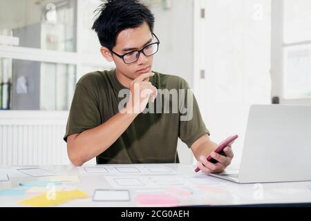 Web designer, UX UI designer designing mobile application user interface. Creative planning application development sketch layout wireframe design. Stock Photo
