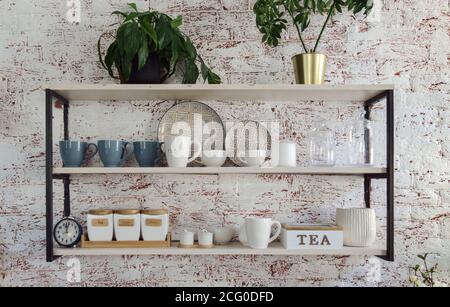 Kitchen glassware Cups and trays on Wooden and metal kitchen shelves Stock Photo