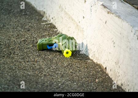 Children's plastic gun for starting soap bubbles lies on the asphalt Stock Photo