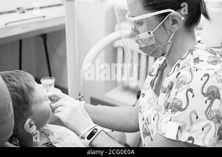 A little boy at a dentist's reception in a dental clinic. Children's dentistry, Pediatric Dentistry. Blac and white retro style photography. Oral heal Stock Photo