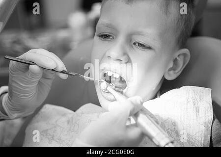 A little boy at a dentist's reception in a dental clinic. Children's dentistry, Pediatric Dentistry. Blac and white retro style photography. Oral heal Stock Photo
