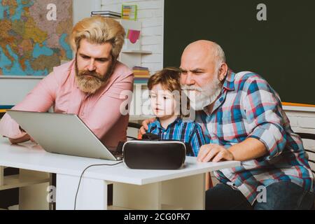 Home education concept. Learning online. Father, Grandfather and child son together. Stock Photo