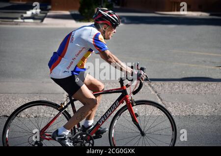 A senior man rides his fitness bicycle along a street in Santa Fe, New Mexico. Stock Photo