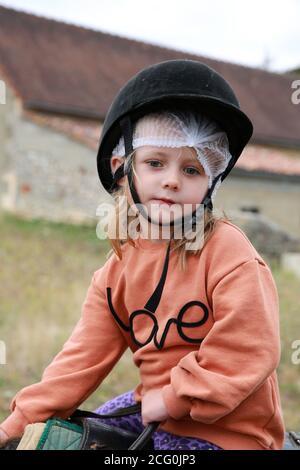 Little girl pony riding at a stables, France