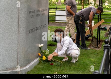 The artist Meredith Bergmann arranges flowers in front of her Women’s Rights Pioneer Monument as Parks Dept. workers finish the installation, on Literary Walk in Central Park in New York on the day of its unveiling, Wednesday, August 26, 2020. The statue, left to right, of Sojourner Truth, Susan B. Anthony and Elizabeth Cady Stanton commemorates the 100 tha anniversary of the 19th amendment which gave women the right to vote. The sculptor is Meredith Bergmann and is the only monument in Central Park depicting real women. (© Richard B. Levine) Stock Photo