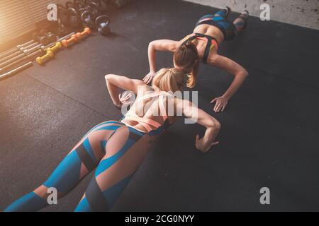 two fit woman in fitness salon in push up pose exercise Stock Photo