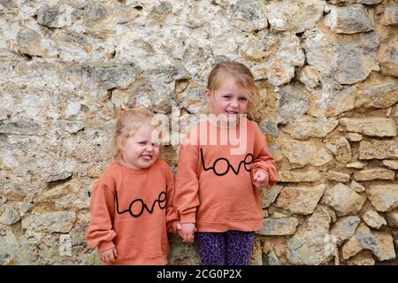 Portrait of two little sisters in matching jumpers. Stock Photo
