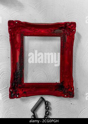 View on isolated old red vintage empty picture frame on white wall (focus on frame) Stock Photo