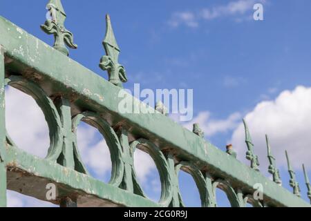 old and rusty peaks on a green fence, vintage Stock Photo