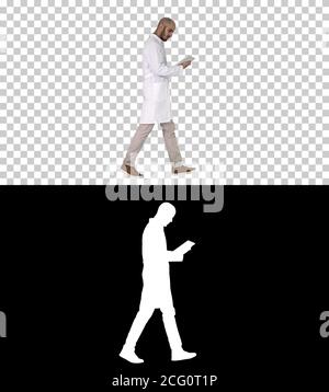 Doctor checking his tablet walking, Alpha Channel Stock Photo