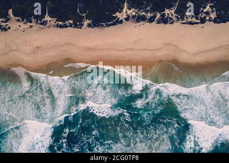 Aerial view of ocean waves running onto pristine stretch of beach Stock Photo