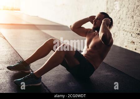 Man with muscular bare torso, ab, six pack, chest, belly, muscles, biceps,  triceps standing with hands on hips on black background. Fitness,  bodybuilding and sport. Power, strength and shape concept Stock Photo 