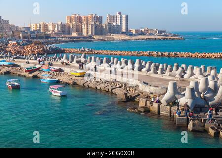 Alexandria, Egypt - December 14, 2018: Landscape with fishermen on concrete breakwater in port of Alexandria, Egypt Stock Photo