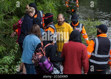 Denham, UK. 8th September, 2020. HS2 security guards try to prevent HS2 Rebellion activists from supporting a fellow activist who had climbed a tree in Denham Country Park in order to try to protect it from works for the HS2 high-speed rail link. Anti-HS2 activists continue to try to prevent or delay works on the controversial £106bn project for which the construction phase was announced on 4th September from a series of protection camps based along the route of the line between London and Birmingham. Credit: Mark Kerrison/Alamy Live News Stock Photo
