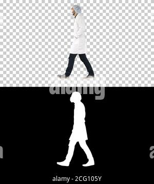 Walking doctor puting medical mask on, Alpha Channel Stock Photo