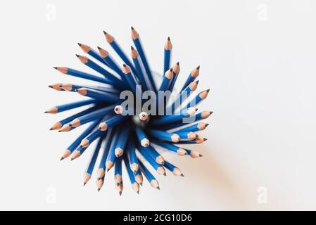 Overhead view of bunch of sharpened blue pencils on white paper. Stock Photo